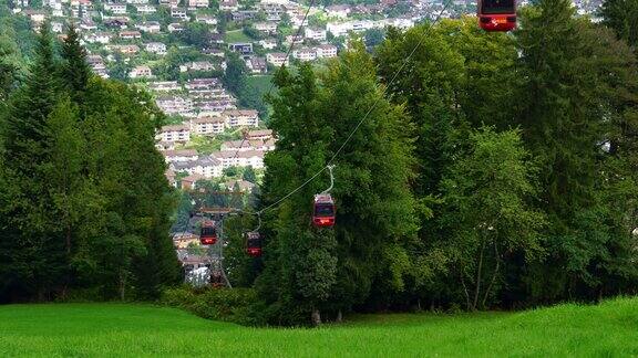 在瑞士卢塞恩的皮勒特斯瑞士阿尔卑斯山脉的绿色山丘上一排缆车缆车经过