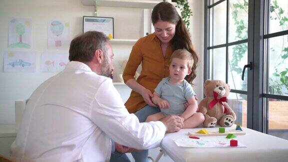一名成熟的儿科医生正在给一名男婴做检查