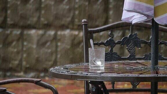 桌子和椅子在夏天的咖啡馆下大雨