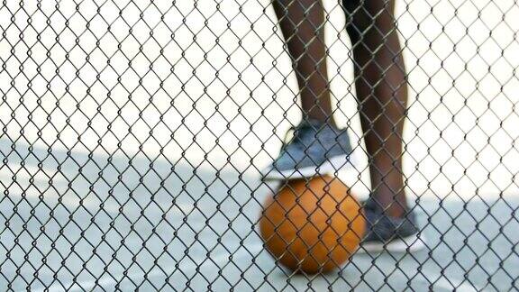 一个穿着运动鞋的非裔美国人在等着球队集合去打篮球