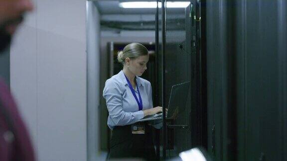 一名年轻男女在服务器室工作时使用无线设备的4k视频片段