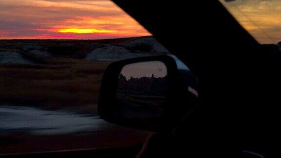 FPV:在令人惊叹的红色日落穿过荒地国家公园沙漠的公路旅行