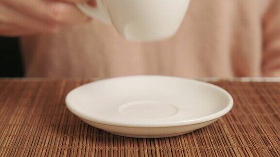 在咖啡馆里一个女人用白色陶瓷杯子喝咖啡