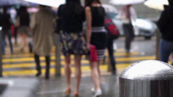 在香港亚洲人在下雨时过马路工商界人士带着雨伞行走