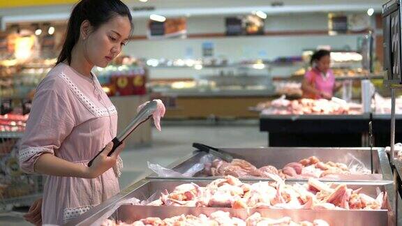 在超市买生鸡肉的女人