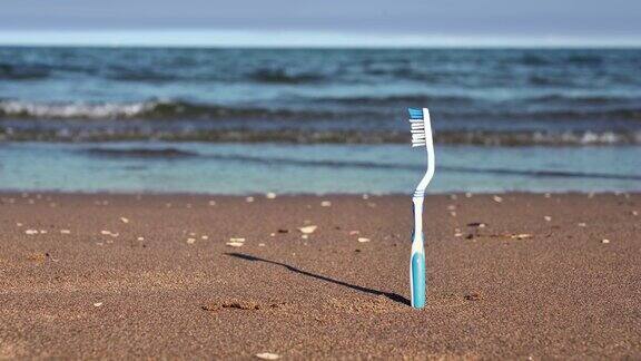 蓝色和白色的牙刷放在沙滩的黄色沙滩上