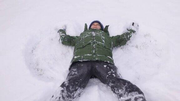 十几岁的男孩喜欢在新雪中做一个雪天使