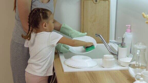 母亲和小女儿在厨房里洗盘子