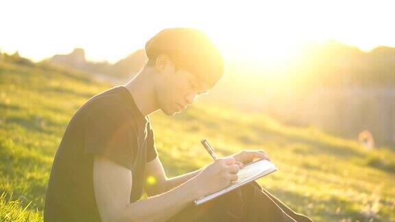 一个男孩坐在草坪上写生