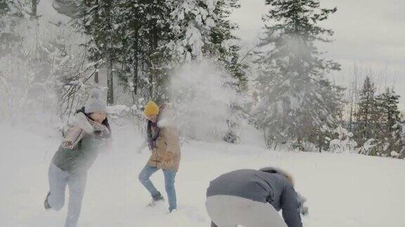 一群朋友在森林里玩雪球笑着享受冬日