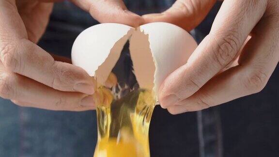女人的手正在打破新鲜的鸡蛋慢动作破鸡蛋掉下来