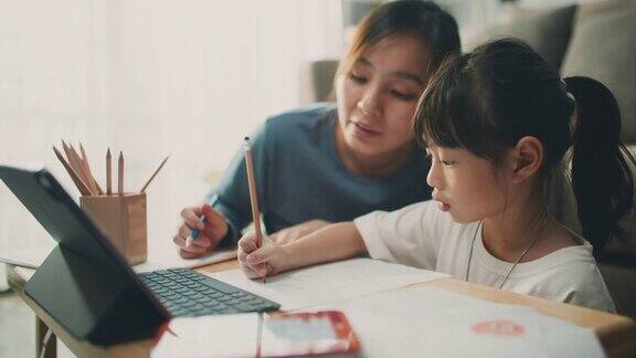 亚裔女儿在家里和母亲一起参加在线课程