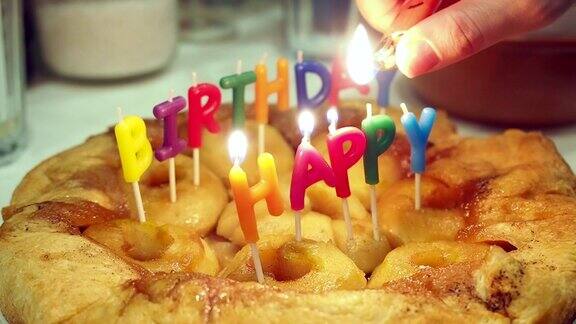 一只手在苹果蛋糕上点燃生日蜡烛