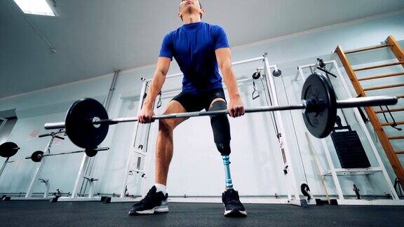 一个戴着仿生腿的男人开始在健身房举重