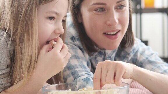妈妈和女儿在家里吃爆米花
