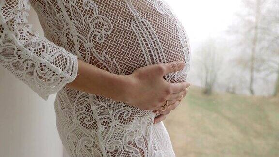 美丽的怀孕金发女孩穿着白色针织连衣裙