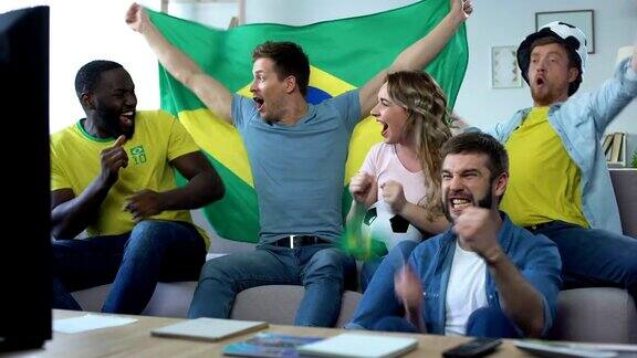 快乐的巴西朋友在家里看比赛庆祝足球队的进球