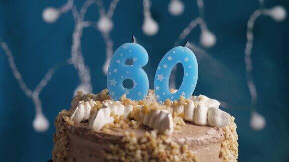 生日蛋糕与60号蜡烛在蓝色背景蜡烛吹灭慢动作和近景