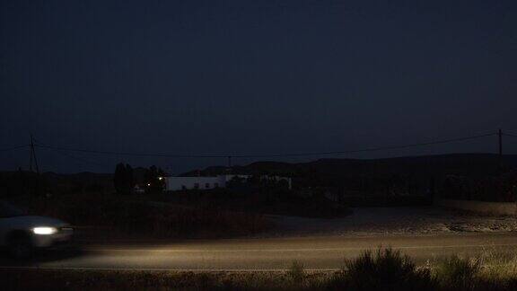 一辆行驶在偏远乡村道路上的汽车夜景