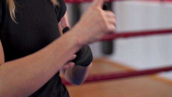 一个职业女拳击手在训练前戴上黑色的手带的特写体育馆里的拳击练习女性职业运动理念