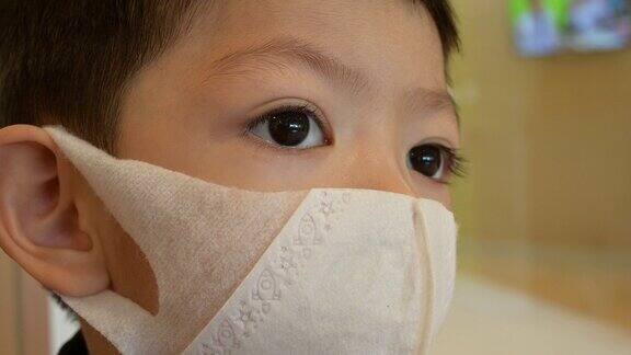 亚洲小男孩戴上卫生防护口罩预防新冠肺炎疫情