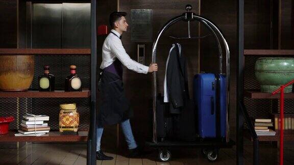 拉丁美洲的行李员推着行李车穿过酒店的走廊