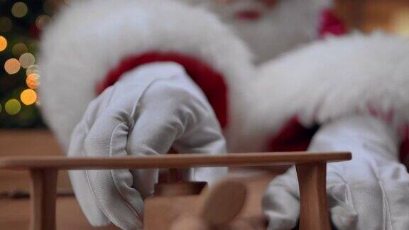 圣诞老人玩着可爱的木制飞机把它放在桌子上我们可以近距离看到它