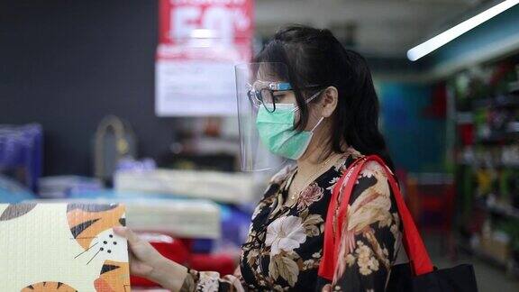 亚洲年轻女子戴着口罩在超市购物