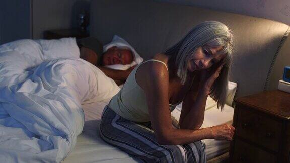 担心的老女人在床上晚上遭受失眠