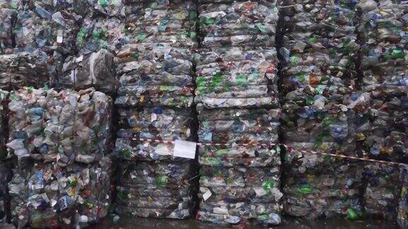在废物回收厂为垃圾回收准备的一捆压过的塑料瓶摄像机移到一边污染问题稳定的视频