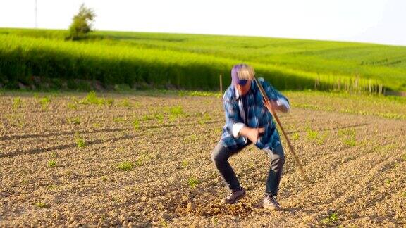 农民在农村耕地上用锄头剪影