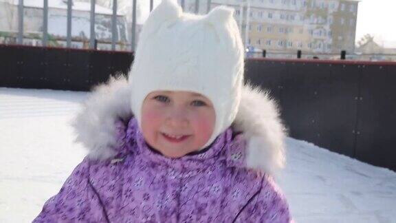 小女孩笑着在冰上溜冰