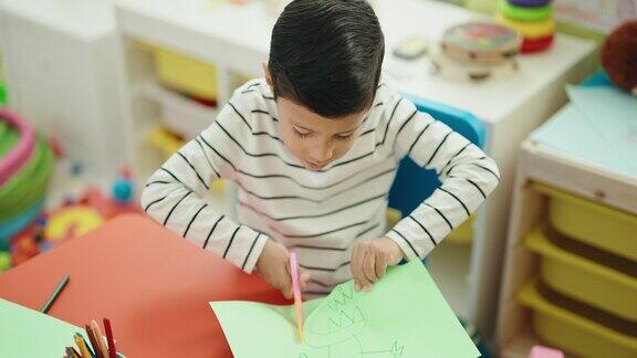 可爱的西班牙男孩在幼儿园剪纸