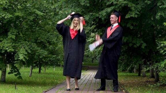 滑稽的毕业生穿着学士服毕业后到处跳舞鬼混