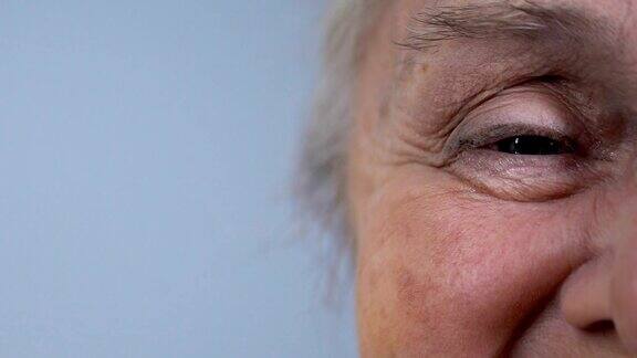 满脸皱纹的老年女性看着镜头人口统计半脸特写