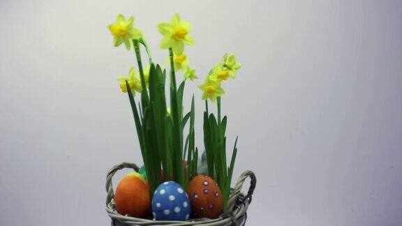 五颜六色的黄色鸡蛋篮子里有鸡蛋和花复活节彩蛋和兔子