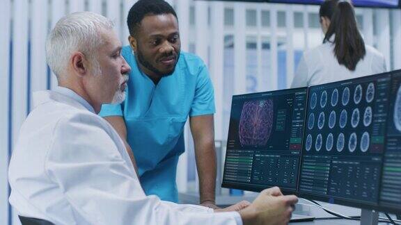 医学科学家和外科医生在实验室用个人电脑讨论CTMRI脑部扫描图像神经研究中心的神经学家神经科学家致力于脑肿瘤的治疗