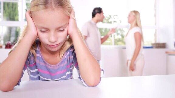 小女孩在吵架的父母面前看起来很沮丧