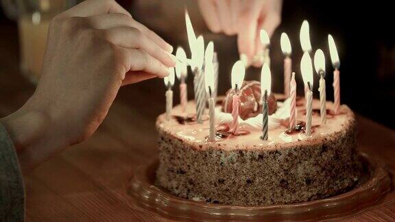 两个人在生日蛋糕上点蜡烛
