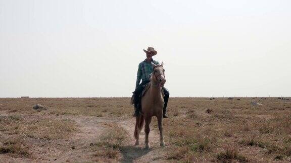 牛仔在陆地上慢慢地骑着马