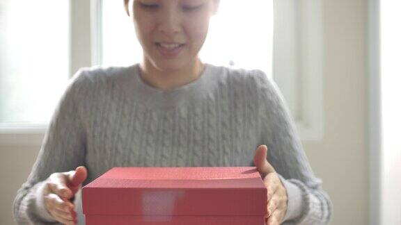 亚洲女人打开红色礼品盒