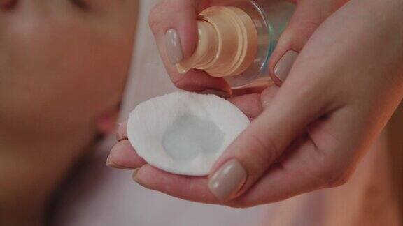 美容师将乳液涂抹在化妆棉上