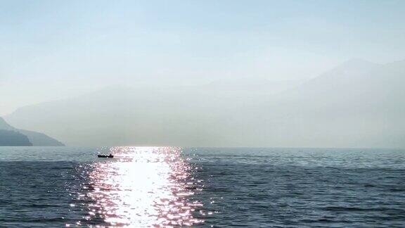 在一个有雾的日子里在一个有山和岛的高山湖上游船
