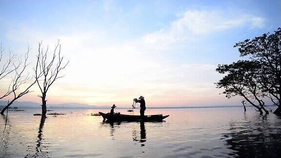 亚洲渔民在木船上撒网在日出前的清晨在自然河流中捕鱼
