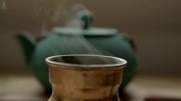 一个传统的咖啡壶在一个绿茶柜子前面有蒸汽