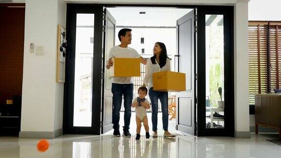 一个年轻的亚洲家庭搬着箱子搬进新家