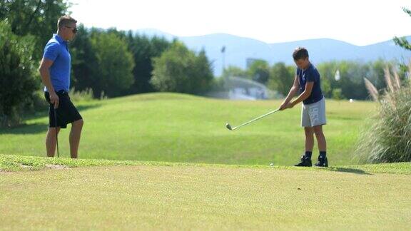 成年高尔夫球手教一个男孩如何打高尔夫球