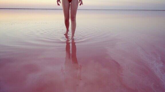 一名女子走在乌克兰的粉色盐湖上