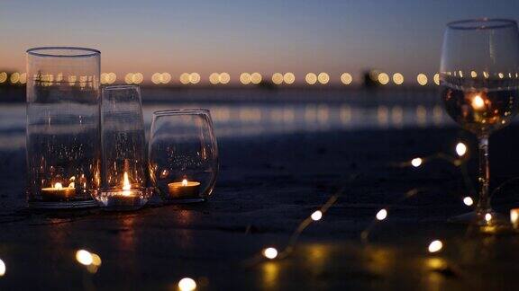 蜡烛火焰灯在玻璃浪漫的海滩约会海浪夏天的海烛光在沙地上