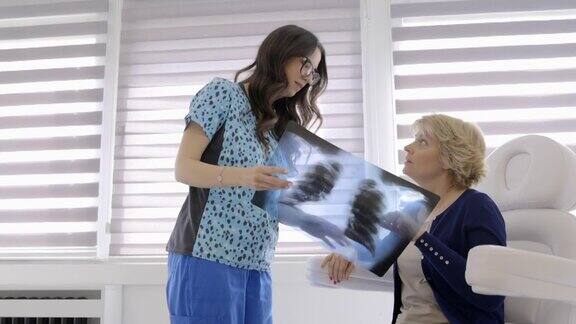 女放射科医生与女病人交谈给她看清晰的肺部x光片